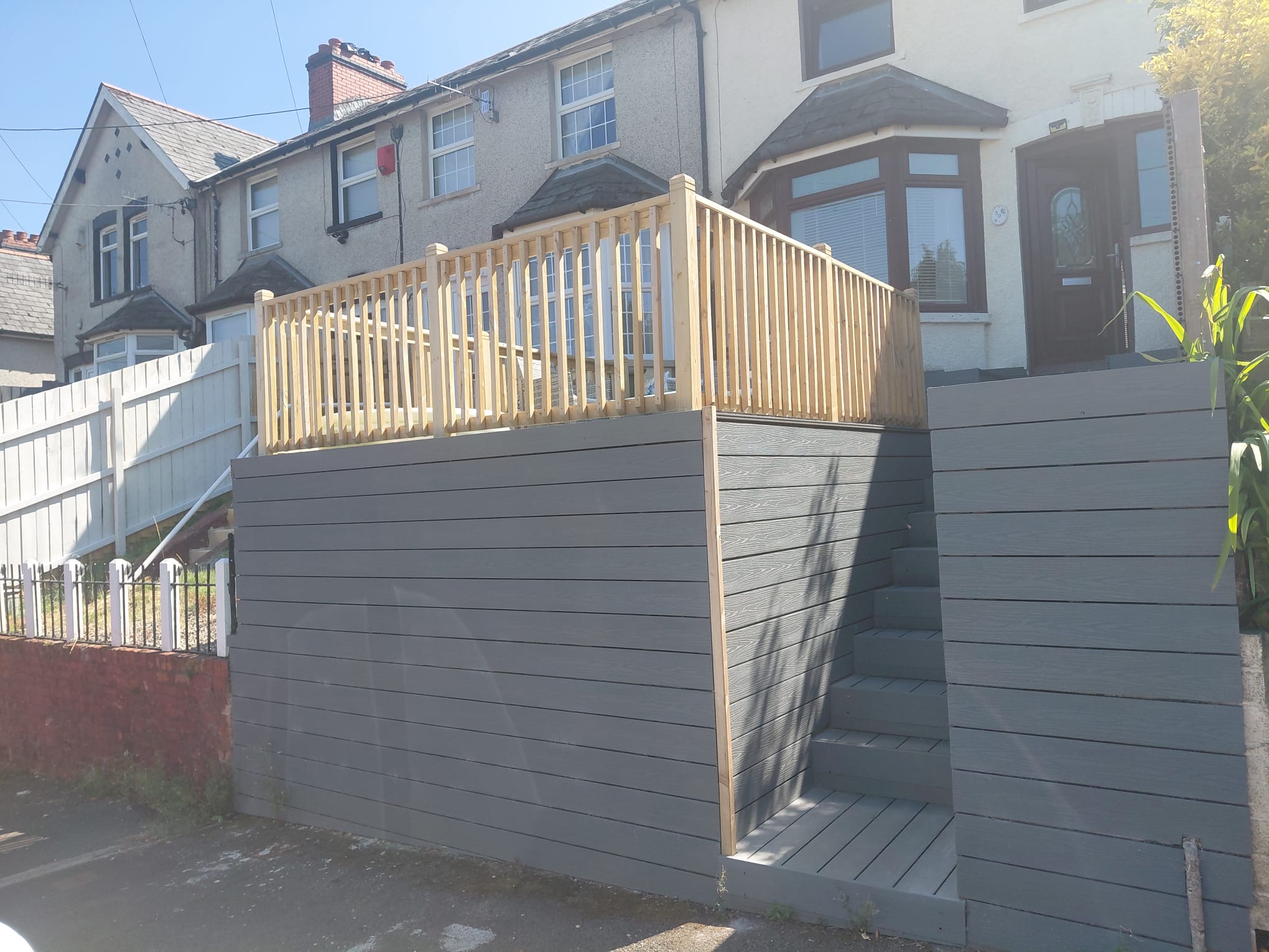 Completed raised composite deck and steps viewed from the street