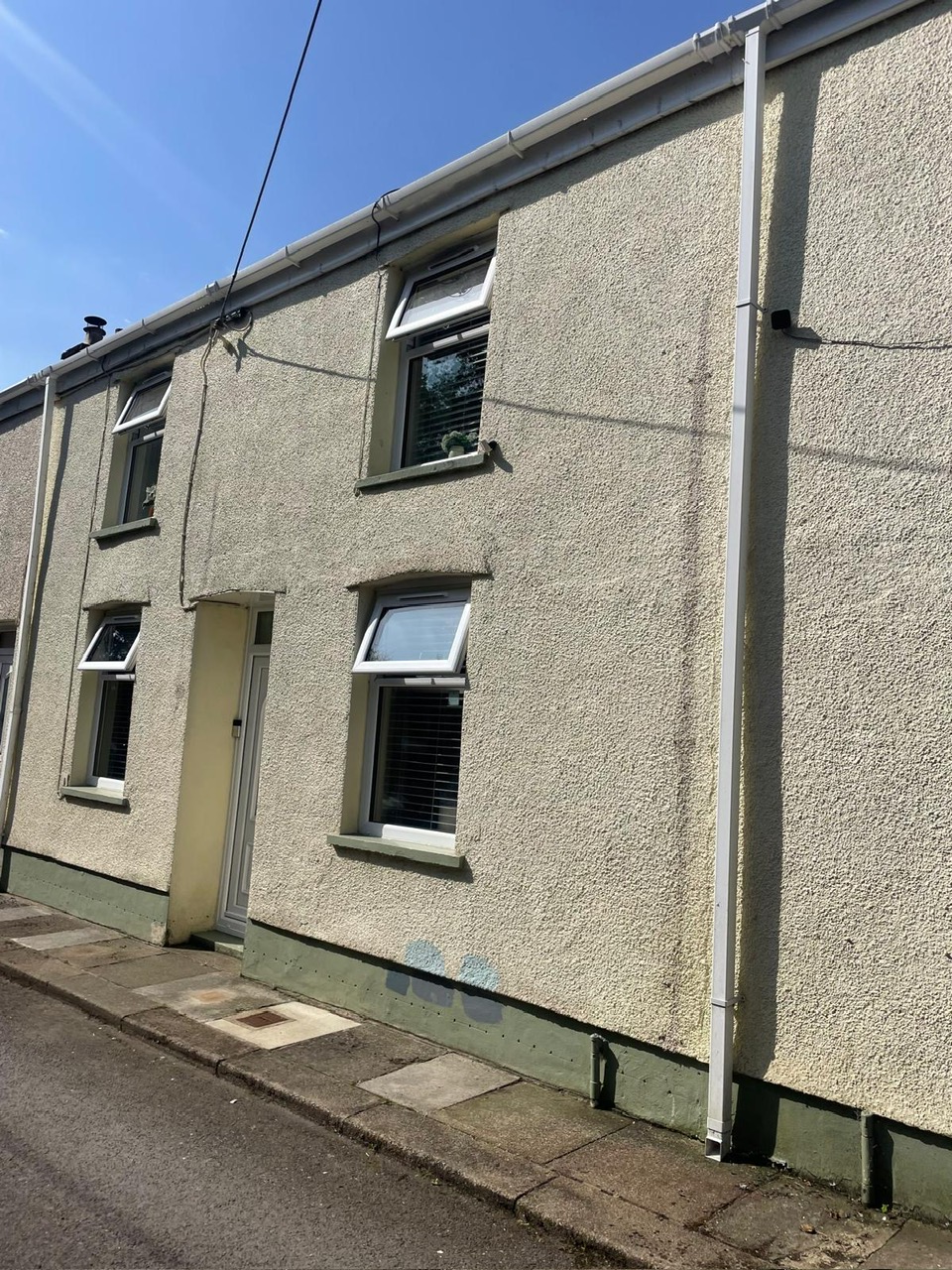 Cream rendered terraced house before exterior decorating